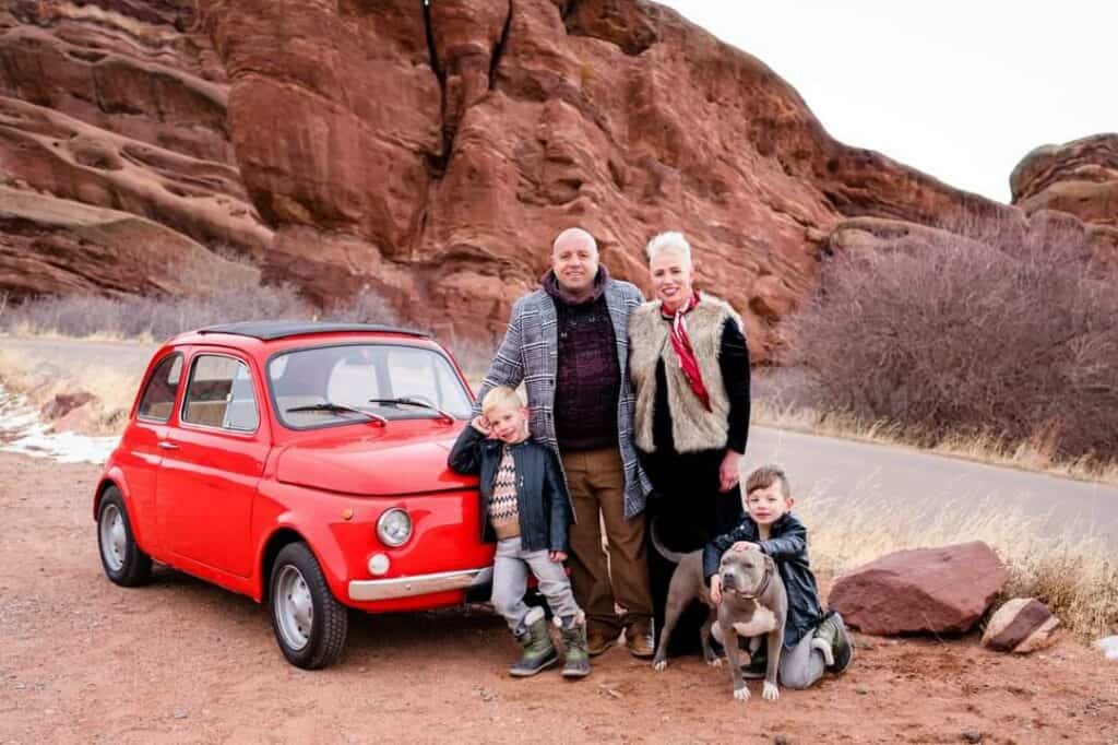 family photo of the owner with the wife, kids, a dog and a red mini car